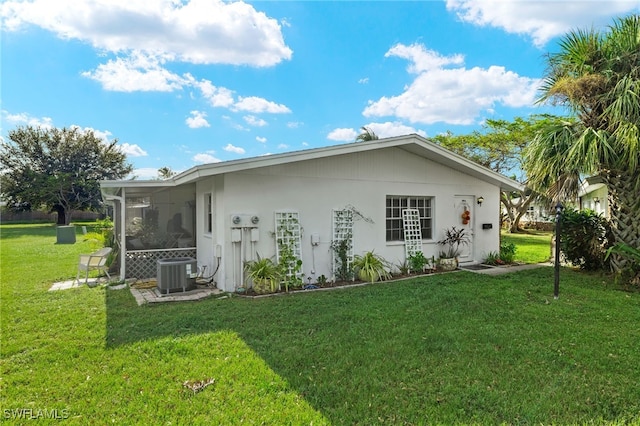 rear view of property with a lawn and central AC unit