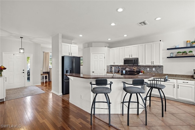 321 Shadow Lakes Dr, Lehigh Acres, FL 33974 - kitchen featuring a kitchen breakfast bar, open shelves, decorative backsplash, white cabinetry, and appliances with stainless steel finishes