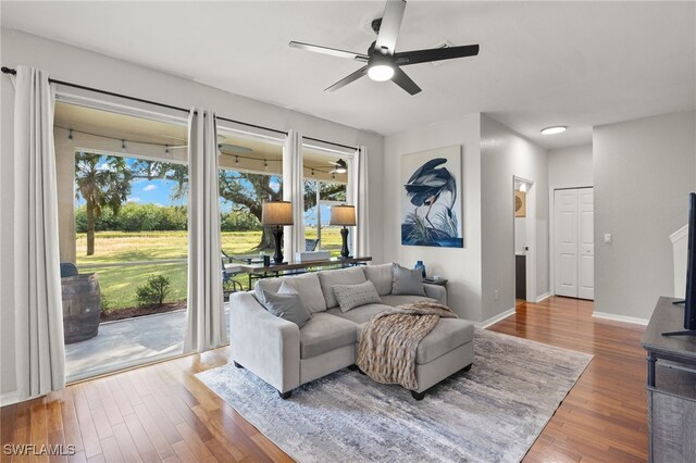 321 Shadow Lakes Dr, Lehigh Acres, FL 33974 - living room featuring ceiling fan, baseboards, wood finished floors, and plenty of natural light
