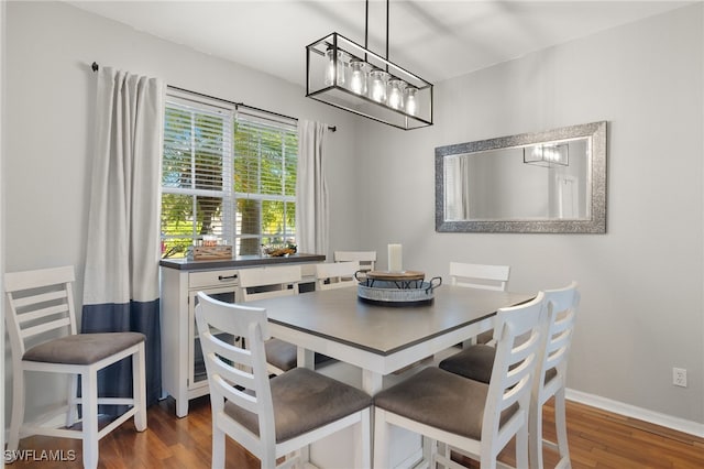 321 Shadow Lakes Dr, Lehigh Acres, FL 33974 - dining area featuring baseboards, wood finished floors, and an inviting chandelier