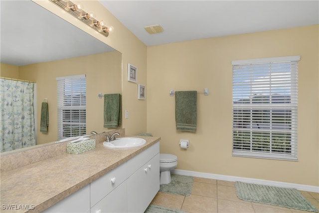 bathroom featuring toilet, vanity, and tile patterned flooring