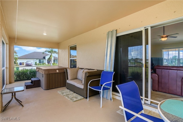 view of patio with ceiling fan and a hot tub