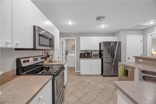 kitchen with white cabinets, washer / dryer, sink, and appliances with stainless steel finishes