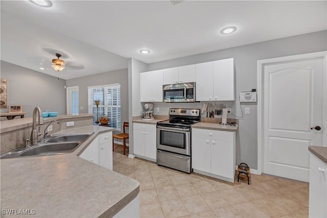 kitchen featuring appliances with stainless steel finishes, white cabinetry, ceiling fan, and sink