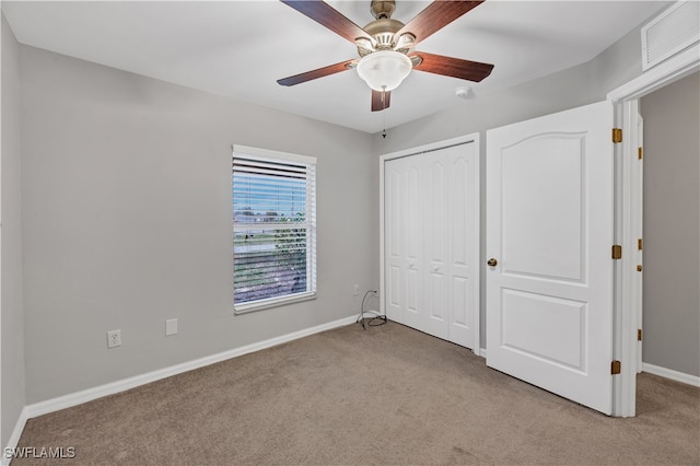 unfurnished bedroom with ceiling fan, light colored carpet, and a closet