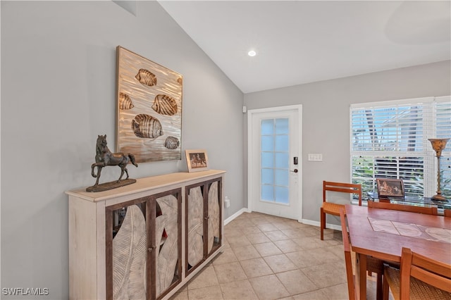 foyer entrance featuring light tile patterned floors and lofted ceiling