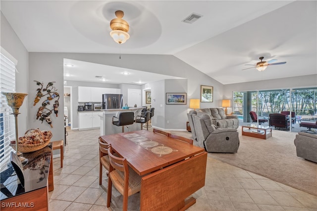 carpeted dining space featuring ceiling fan and lofted ceiling