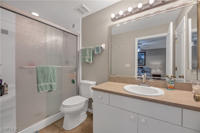 bathroom with tile patterned flooring, vanity, toilet, and walk in shower