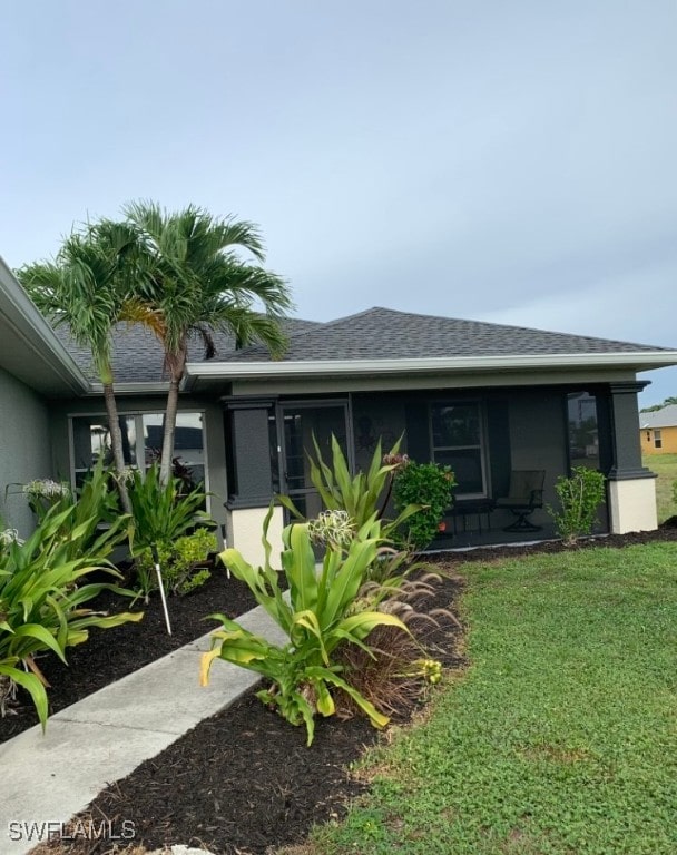 view of front of home featuring a sunroom and a front lawn