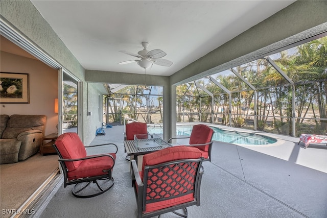 sunroom / solarium with ceiling fan and a pool