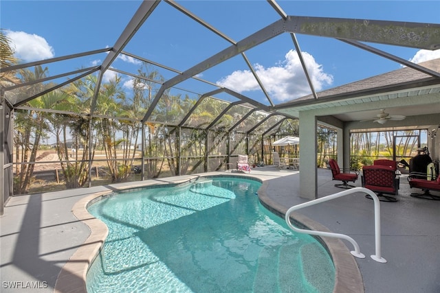 view of pool featuring a patio, glass enclosure, and ceiling fan