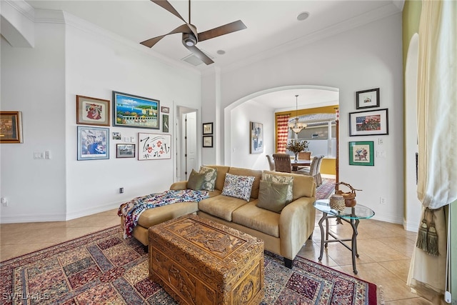 living room with ceiling fan with notable chandelier, light tile patterned floors, and crown molding