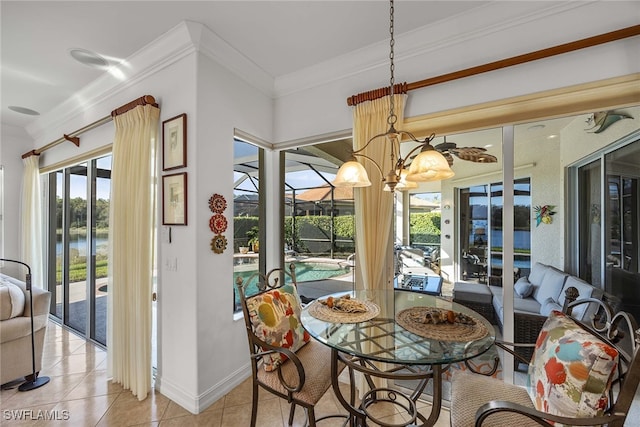 tiled dining room with a chandelier, a water view, and ornamental molding