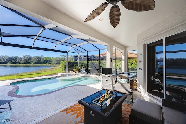 view of pool featuring glass enclosure, a water view, a jacuzzi, ceiling fan, and a patio area