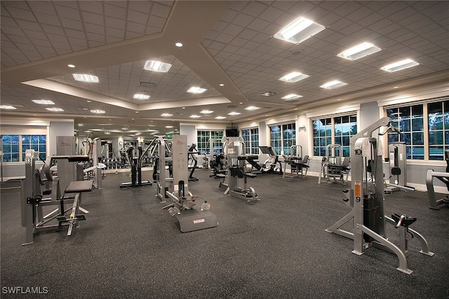 exercise room with a paneled ceiling and a raised ceiling