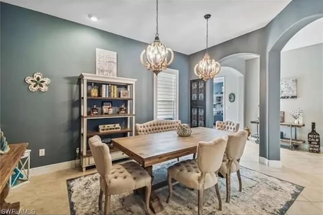 tiled dining space featuring an inviting chandelier