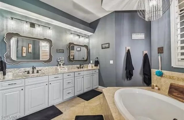 bathroom with vanity, a relaxing tiled tub, a chandelier, and tile patterned flooring