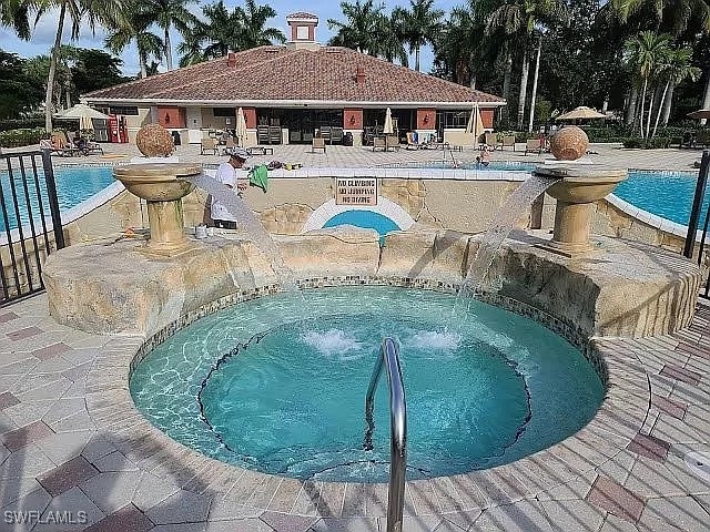 view of swimming pool featuring a hot tub and a patio area