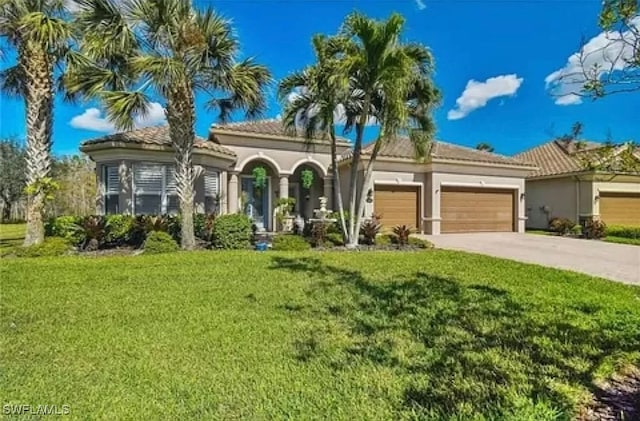 mediterranean / spanish home featuring a front lawn and a garage