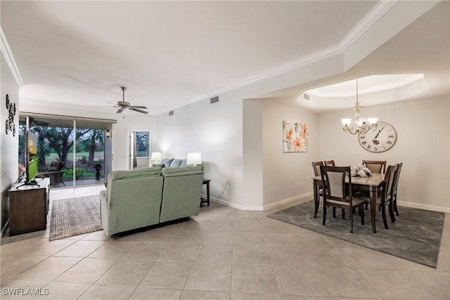 tiled living room with crown molding, ceiling fan with notable chandelier, and a raised ceiling