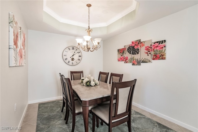 tiled dining space with a raised ceiling, a notable chandelier, and ornamental molding