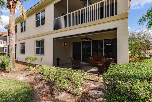 rear view of house with ceiling fan, outdoor lounge area, a balcony, and a patio