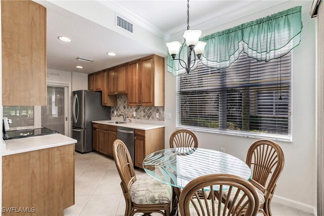 kitchen with tasteful backsplash, a notable chandelier, sink, stainless steel appliances, and light tile patterned floors