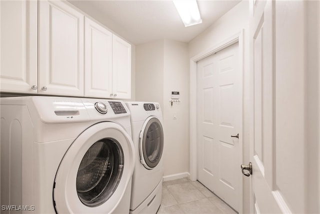 clothes washing area featuring cabinets, light tile patterned flooring, and independent washer and dryer