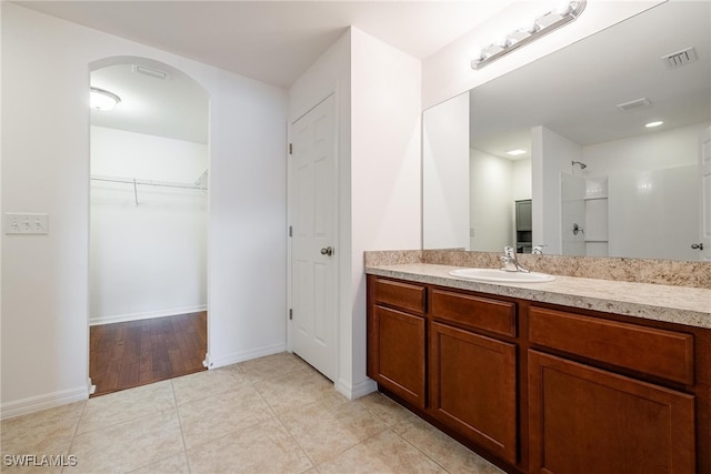 bathroom featuring vanity, tile patterned flooring, and walk in shower