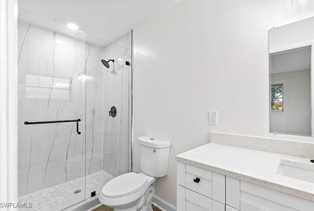 bathroom featuring toilet, a shower with shower door, and vanity