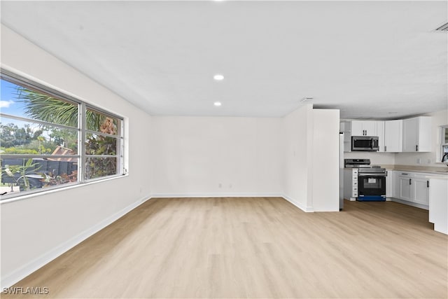 unfurnished living room featuring light hardwood / wood-style floors and sink