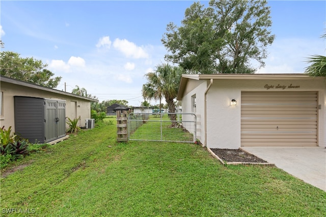 view of yard featuring a garage and central AC unit