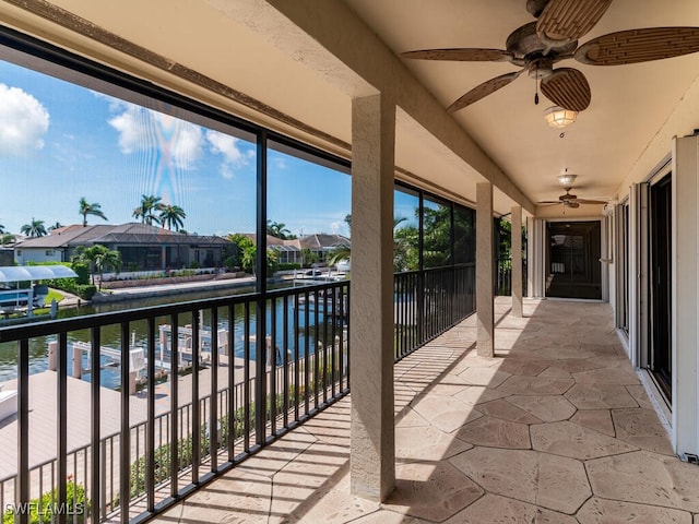 balcony featuring ceiling fan and a water view