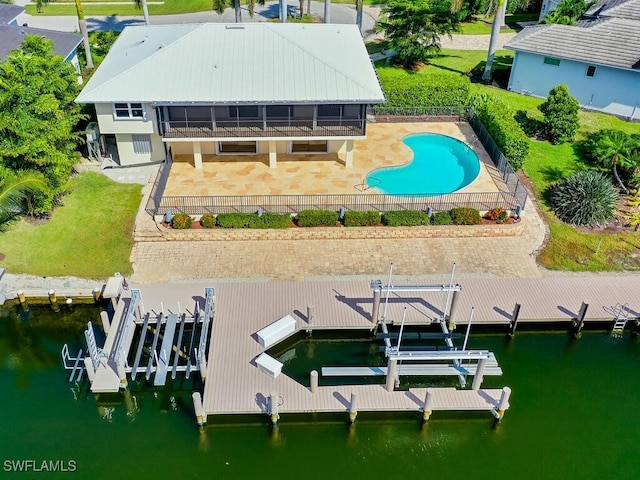 exterior space featuring a water view, a fenced in pool, and a patio area