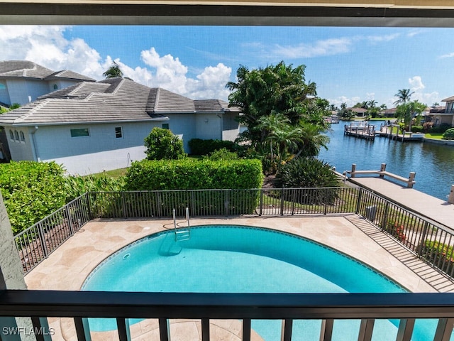 view of swimming pool with a water view and a patio area