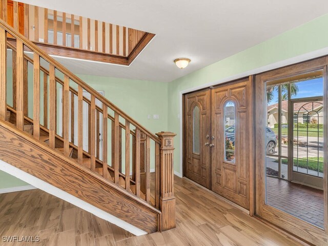 foyer with french doors and light hardwood / wood-style floors