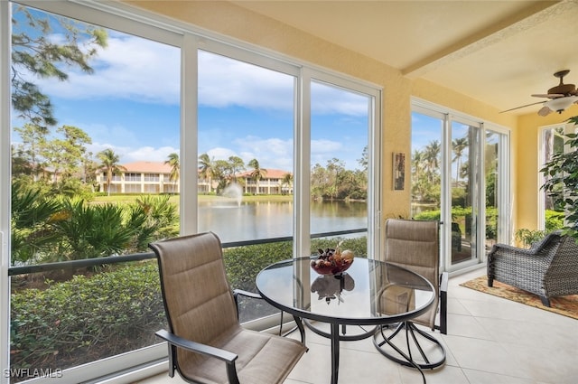 sunroom / solarium featuring a water view and ceiling fan