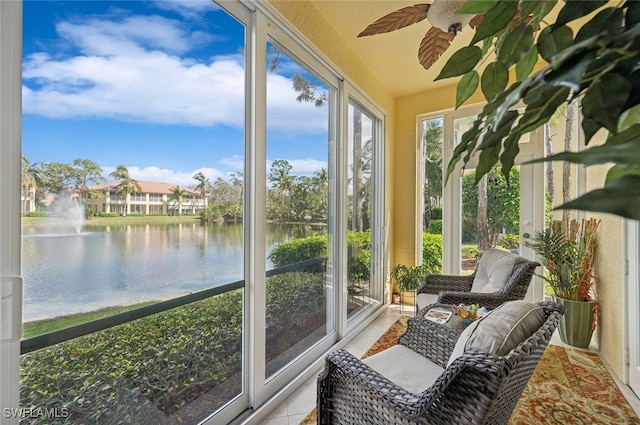 sunroom featuring plenty of natural light, a water view, and ceiling fan