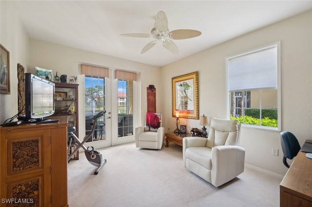 living area with french doors, ceiling fan, plenty of natural light, and light colored carpet