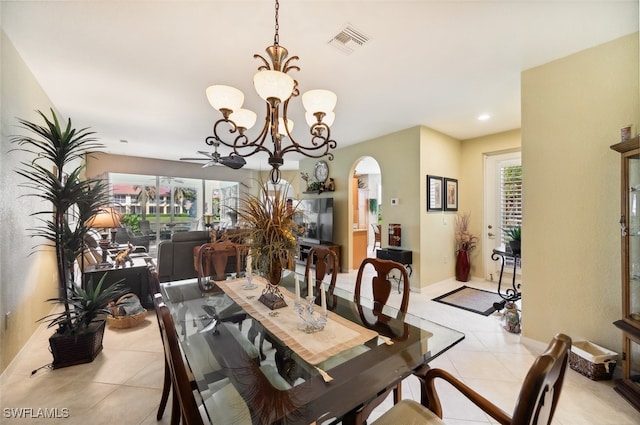 tiled dining area featuring ceiling fan with notable chandelier