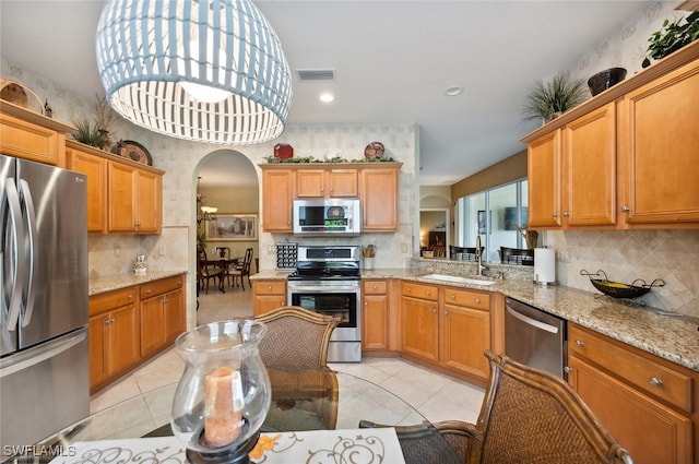 kitchen with decorative backsplash, stainless steel appliances, sink, light tile patterned flooring, and decorative light fixtures