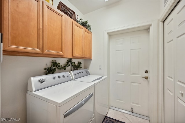 laundry area featuring cabinets, light tile patterned flooring, and washing machine and clothes dryer