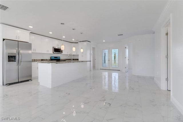 kitchen featuring stainless steel appliances, a center island with sink, sink, pendant lighting, and white cabinetry