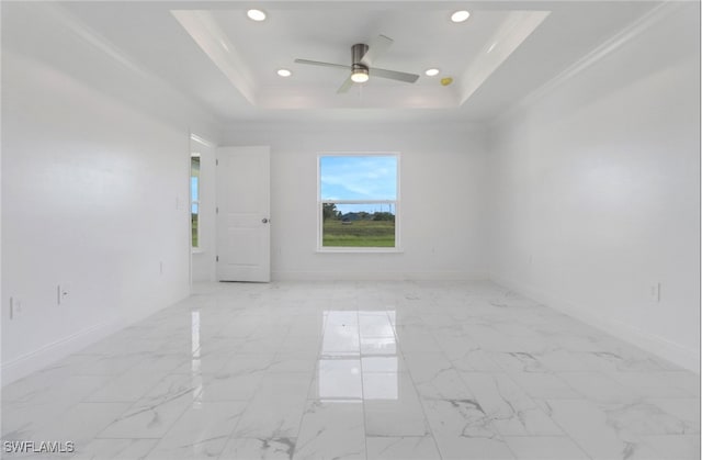 empty room with ceiling fan, a raised ceiling, and crown molding