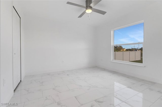 381 Paulcrest Ave, Lehigh Acres, FL 33974 - spare room featuring baseboards, marble look tiles, and a ceiling fan
