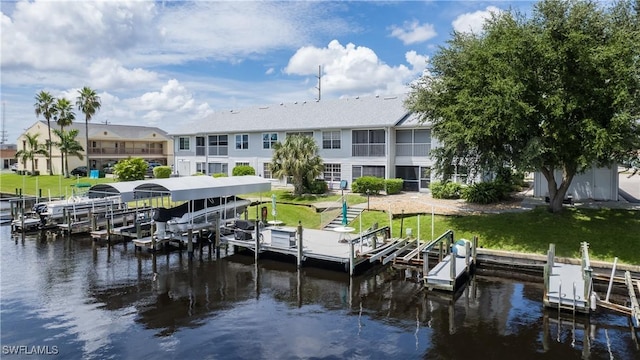 dock area with a residential view, a water view, a yard, and boat lift