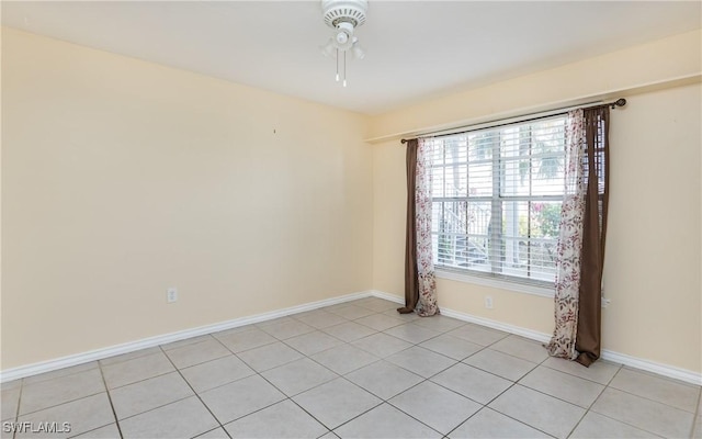 unfurnished room featuring baseboards, a ceiling fan, and light tile patterned flooring