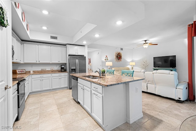 kitchen featuring appliances with stainless steel finishes, sink, ceiling fan, white cabinets, and a center island with sink