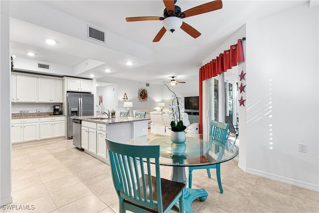 dining area with sink, ceiling fan, and light tile patterned floors