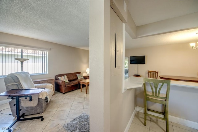 living room featuring a textured ceiling and light tile patterned flooring